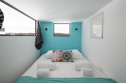 un letto in una camera con pareti e finestre blu di L'instant - Appt climatisé pour 4 , centre Rennes a Rennes
