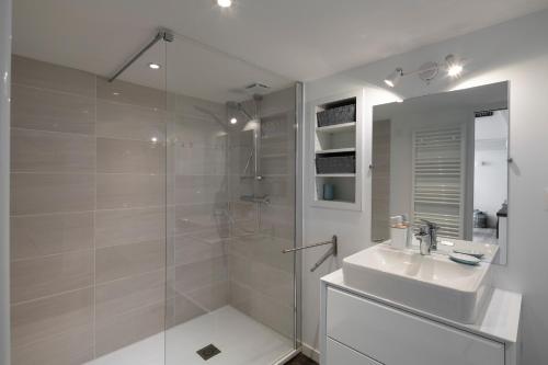 un bagno con doccia, lavandino e specchio di L'instant - Appt climatisé pour 4 , centre Rennes a Rennes