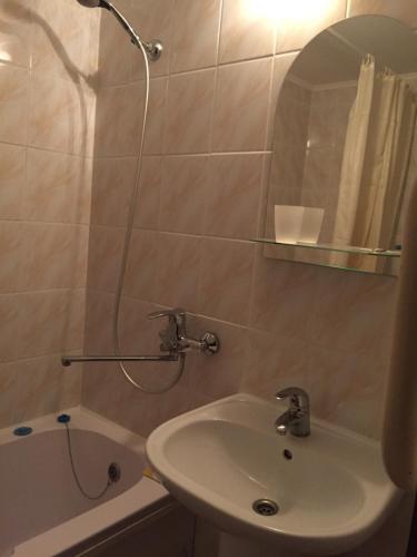 a bathroom with a sink and a shower with a mirror at Двухкомнатная квартира с видом на море in Chornomorsk