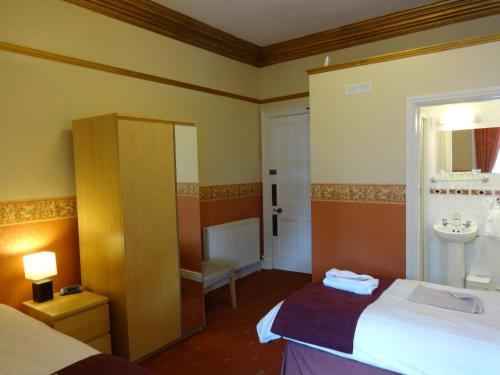a hotel room with a bed and a sink at Dumfries Villa in Dumfries