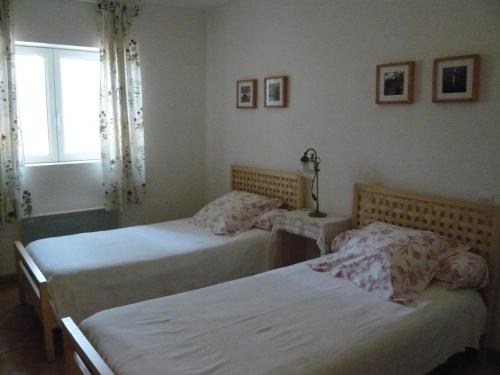 a bedroom with two beds and a window at Le Soubiran in Bérat