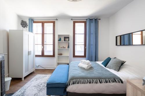 a bedroom with a large bed with a blue bench at Saint Germain RENNES by Cocoonr in Rennes