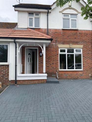 a brick house with a brick driveway at Sunset Homes in London