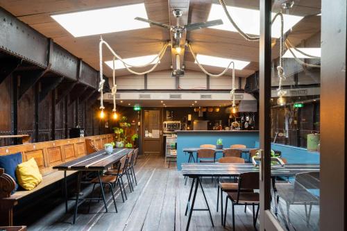 een restaurant met houten vloeren en tafels en stoelen bij B&B Vita Nova in Amersfoort
