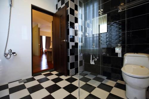 a bathroom with a toilet and a black and white checkered floor at 花蓮知卡宣民宿 in Jian