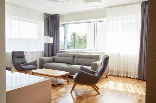 a living room with a couch and two chairs at Tallink Spa & Conference Hotel in Tallinn