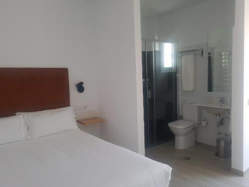 a bedroom with a bed and a bathroom with a toilet at Basic Hotel Sevilla Catedral in Seville