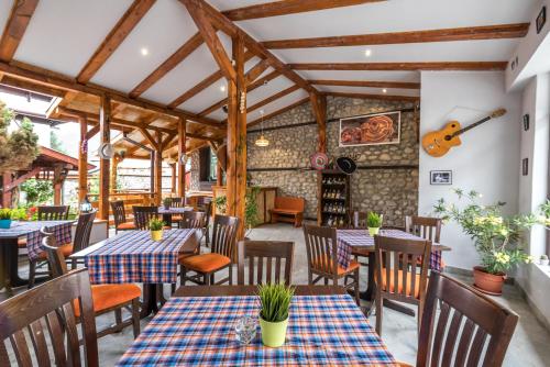 a restaurant with tables and chairs and a guitar on the wall at Hotel Ida in Bansko