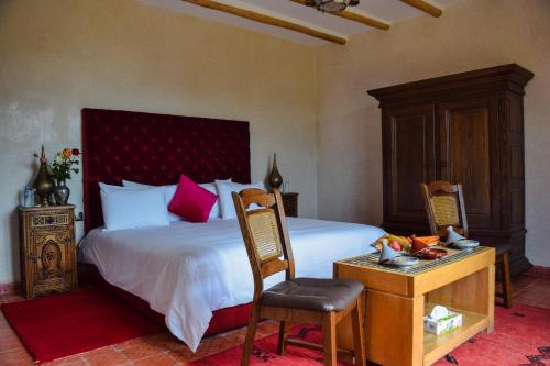 a bedroom with a bed and a table with a chair at Tizi N'Ouirgane in Marrakech