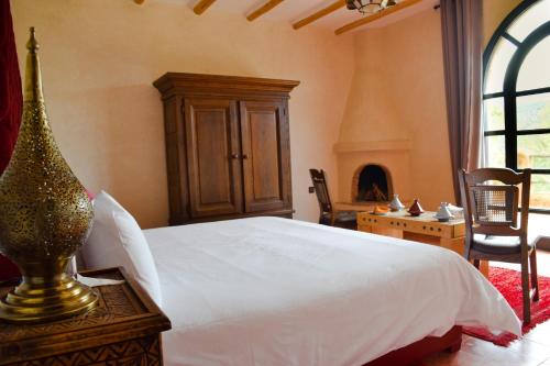 a bedroom with a white bed and a fireplace at Tizi N'Ouirgane in Marrakech