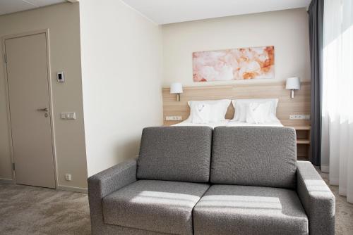 a bedroom with a bed and a couch at Tallink Spa & Conference Hotel in Tallinn