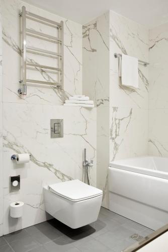 a white bathroom with a toilet and a sink at Tallink Spa & Conference Hotel in Tallinn