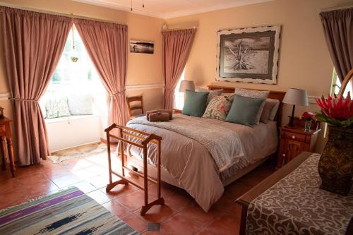 Un pat sau paturi într-o cameră la Roses and Pebbles B & B Guest House