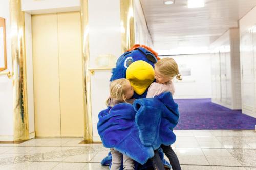 two little girls carrying a large stuffed animal in a hallway at DFDS Ferry - Copenhagen to Oslo in Copenhagen