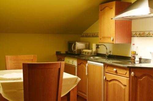 a kitchen with wooden cabinets and a counter top at Posada El Arrabal in Arenas de Iguña
