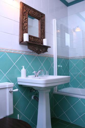 a bathroom with a sink and a mirror and a toilet at Posada El Arrabal in Arenas de Iguña