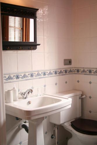 a bathroom with a sink and a toilet at Posada El Arrabal in Arenas de Iguña