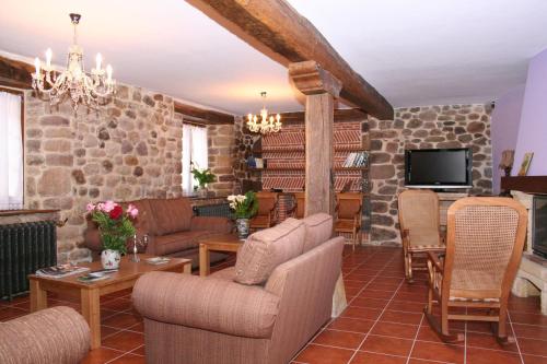 uma sala de estar com uma parede de pedra em Posada El Arrabal em Arenas de Iguña