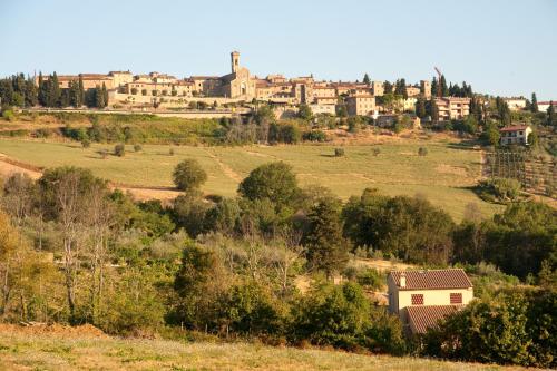 a small house in a field with a town in the background at Due Piani in Barberino di Val dʼElsa