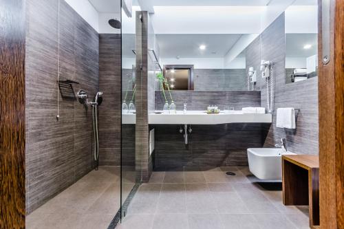 y baño con ducha, lavabo y bañera. en Hotel Villa Batalha, en Batalha