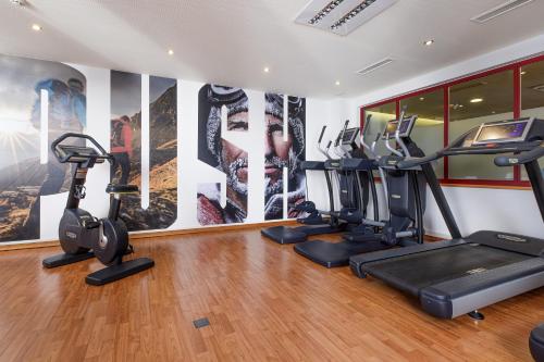 a gym with treadmills ellipticals and exercise bikes at DAS VIER Sport,- und Wellnesshotel in Sankt Leonhard im Pitztal