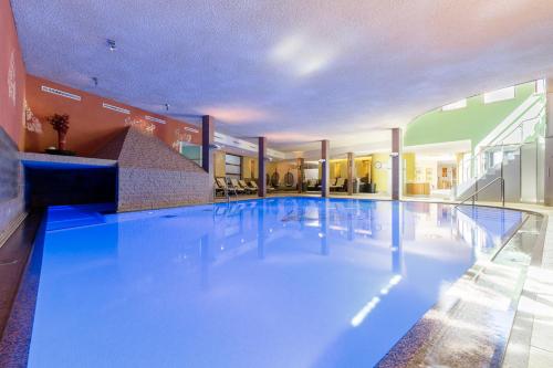 a large swimming pool in a building at DAS VIER Sport,- und Wellnesshotel in Sankt Leonhard im Pitztal