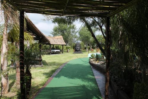 a walkway in a garden with a green path at Hotel Copacabana Tarifa Beach in Tarifa