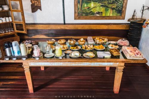 a table with a variety of breakfast foods on it at Pousada Anauê Cipó in Serra do Cipo