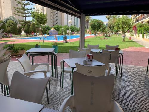 un patio vacío con mesas y sillas y una piscina en Apartamento Dreamplace, en Finestrat