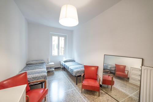 Cette chambre comprend deux lits, un miroir et des chaises. dans l'établissement Cocca's House by PortofinoVip, à Portofino