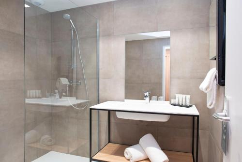 La salle de bains est pourvue d'un lavabo et d'une douche. dans l'établissement Domaine De Saint Clair Spa & Golf, à Saint-Clair