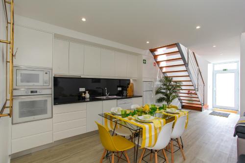 a kitchen with a table with yellow chairs in a kitchen at Casa Nostra in Furnas