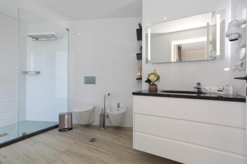 biała łazienka z umywalką i prysznicem w obiekcie Casa Nostra w mieście Furnas