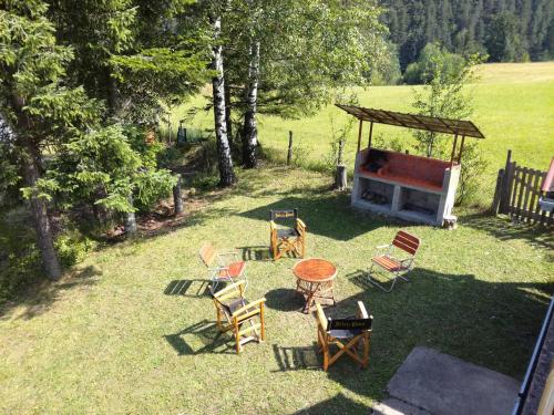 a backyard with a table and chairs and a grill at Apartmani LUFT in Bajina Bašta
