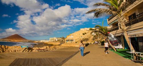 people walking on a boardwalk on the beach at Casa Grande Surf Hostel in El Médano