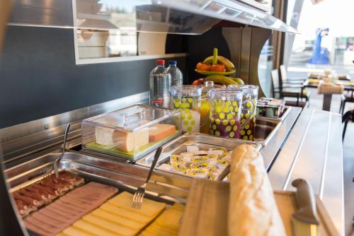 a buffet line in a restaurant with many different foods at Le Merceny Motel in Bastogne