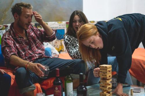 a woman leaning over to play a game of dominoes at Casa Grande Surf Hostel in El Médano