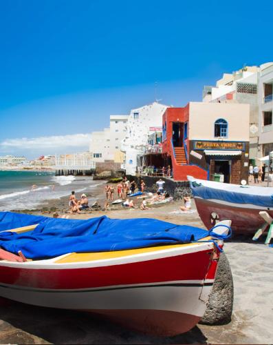 a boat on the beach with people on the beach at Casa Grande Surf Hostel in El Médano