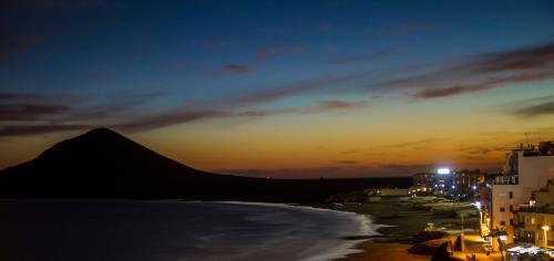 a view of a beach at night with a mountain at Casa Grande Surf Hostel in El Médano