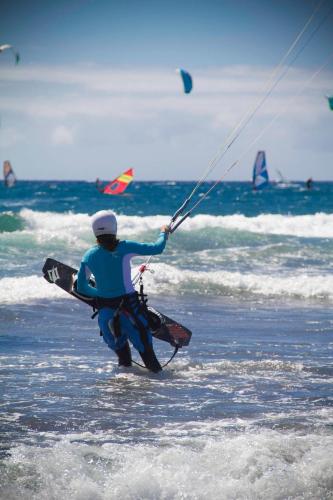a man holding a kite on the beach at Casa Grande Surf Hostel in El Médano