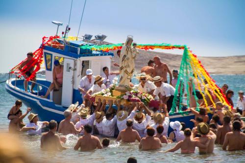 a group of people in the water near a boat at Casa Grande Surf Hostel in El Médano
