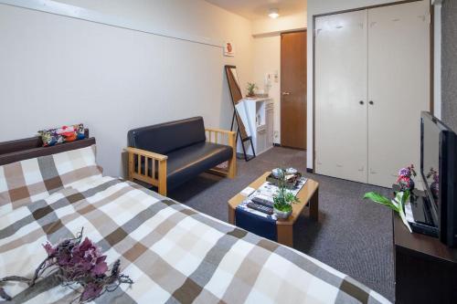 een hotelkamer met een bed en een stoel bij Cozy house 8, free wifi a rented electric bicycle in Kyoto