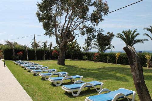 a row of lounge chairs in a park at Hotel Copacabana Tarifa Beach in Tarifa