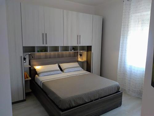 1 dormitorio con 1 cama grande y armarios blancos en Tra cielo e mare, en Gaeta