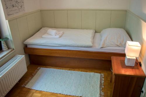 a small bed in a small room with a table at Guest House Park Žibert in Ljubljana