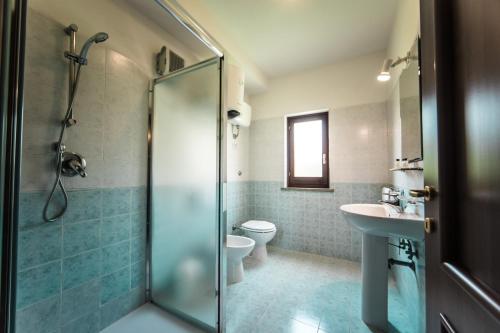a bathroom with a shower and a toilet and a sink at Borgo Venecca in Fonteblanda