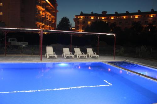 a swimming pool with lounge chairs at Gül Otel in Belek