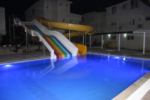 a slide in a swimming pool at night at Gül Otel in Belek
