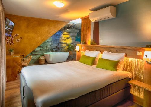 Hotel Abdij de Westerburcht في فيستبورك: غرفة نوم مع سرير مع حوض استحمام فيه
