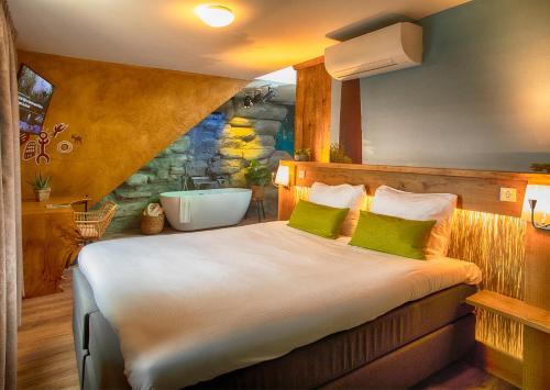 a bedroom with a bed with a bath tub in it at Boutique Hotel, Restaurant & Wellness Westerburcht in Westerbork